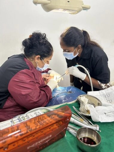 Periodontist explaining gum surgery with a 3D model to patient in advanced dental clinic.