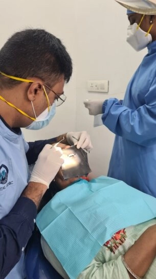 Young Indian man smiling brightly in a dental clinic, showing clean white teeth and a friendly, healthy appearance.