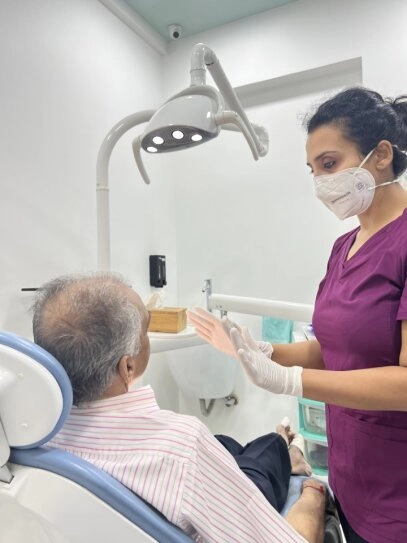 Confident Indian woman smiling with perfect teeth in a modern dental clinic, showcasing a healthy and happy smile.